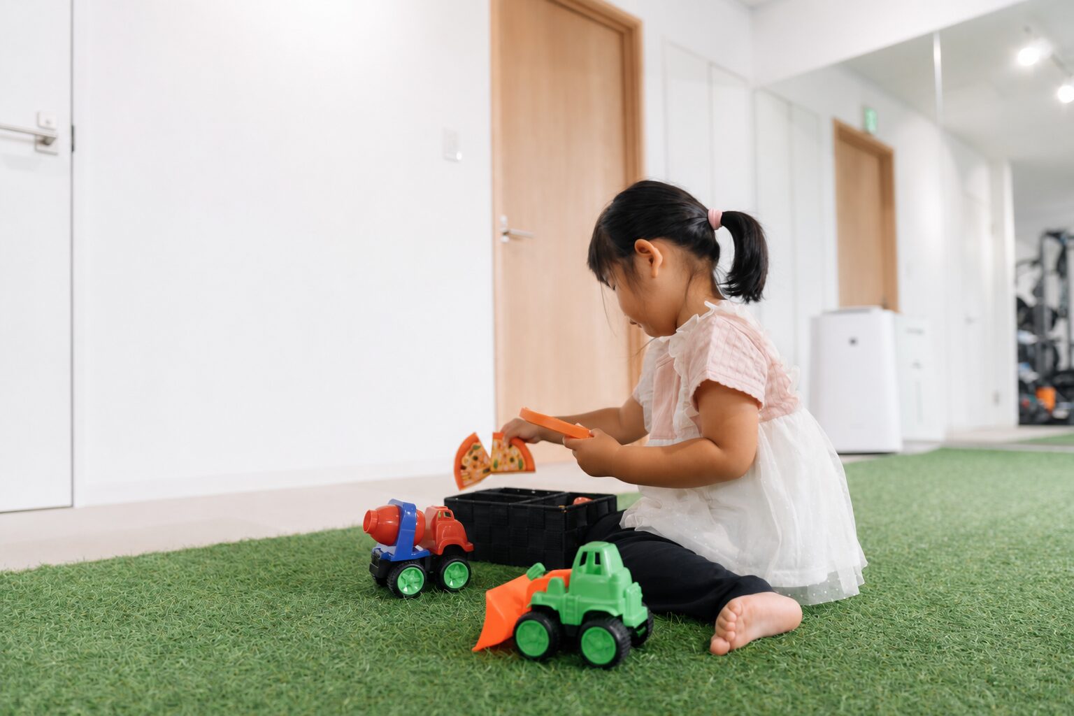 人工芝の待機スペースでおもちゃ遊びをする子ども｜子連れOKのパーソナルジムTRAD